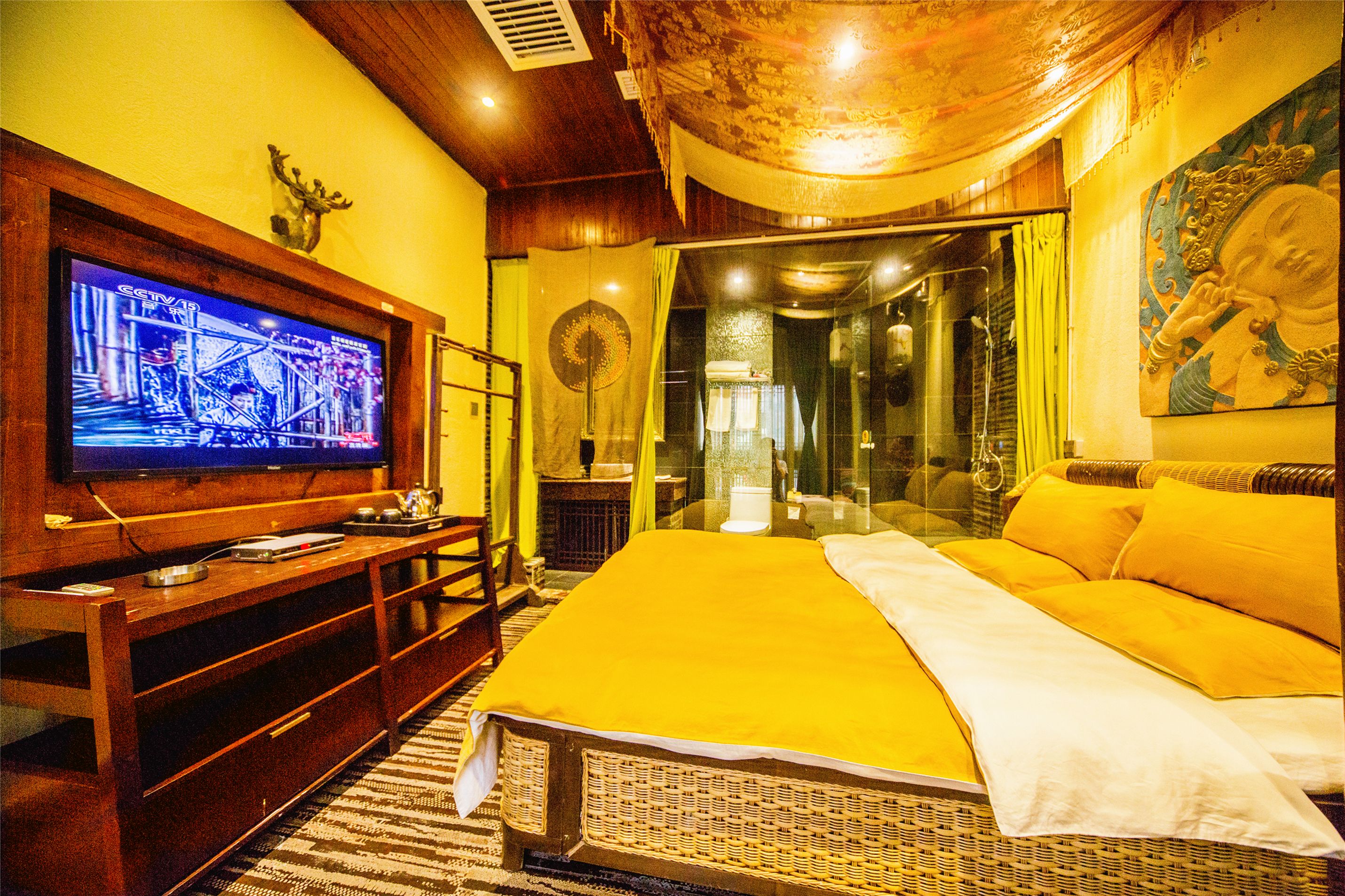 A room with a large bed, a television, and a mirror.