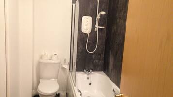 Un baño pequeño con inodoro, ducha y bañera.