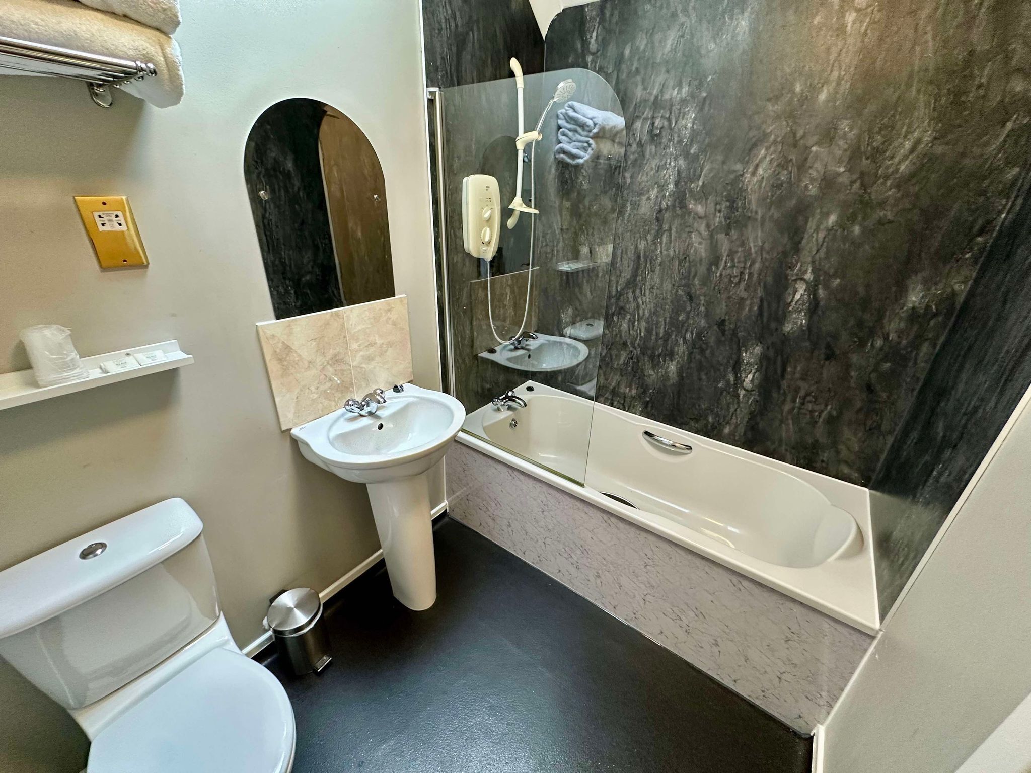Une salle de bain avec des toilettes, un lavabo et une baignoire.
