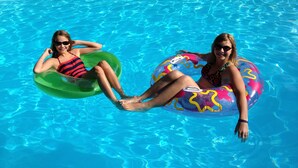 Two people in a swimming pool with inflatable rings. - Golden Stage Inn B&B (Cavendish)