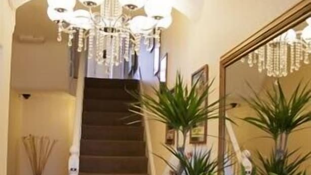 A staircase leading to a second floor, flanked by a mirror and potted plants. - Balmoral (Skegness)