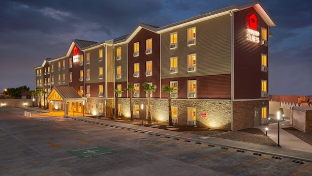 A multi-story hotel with a stone facade, multiple balconies, and a well-lit entrance. - Extended Suites Tijuana Macroplaza (Tijuana)