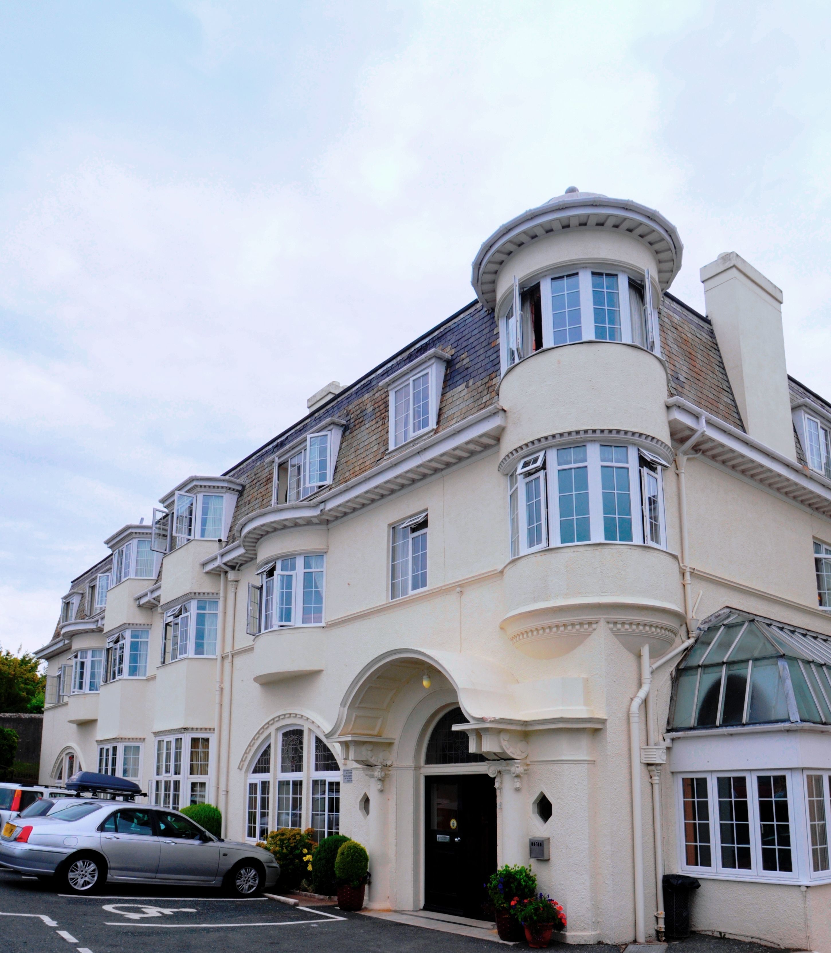 A large, multi-story building with a classic architectural style, featuring arched windows and a prominent central entrance.