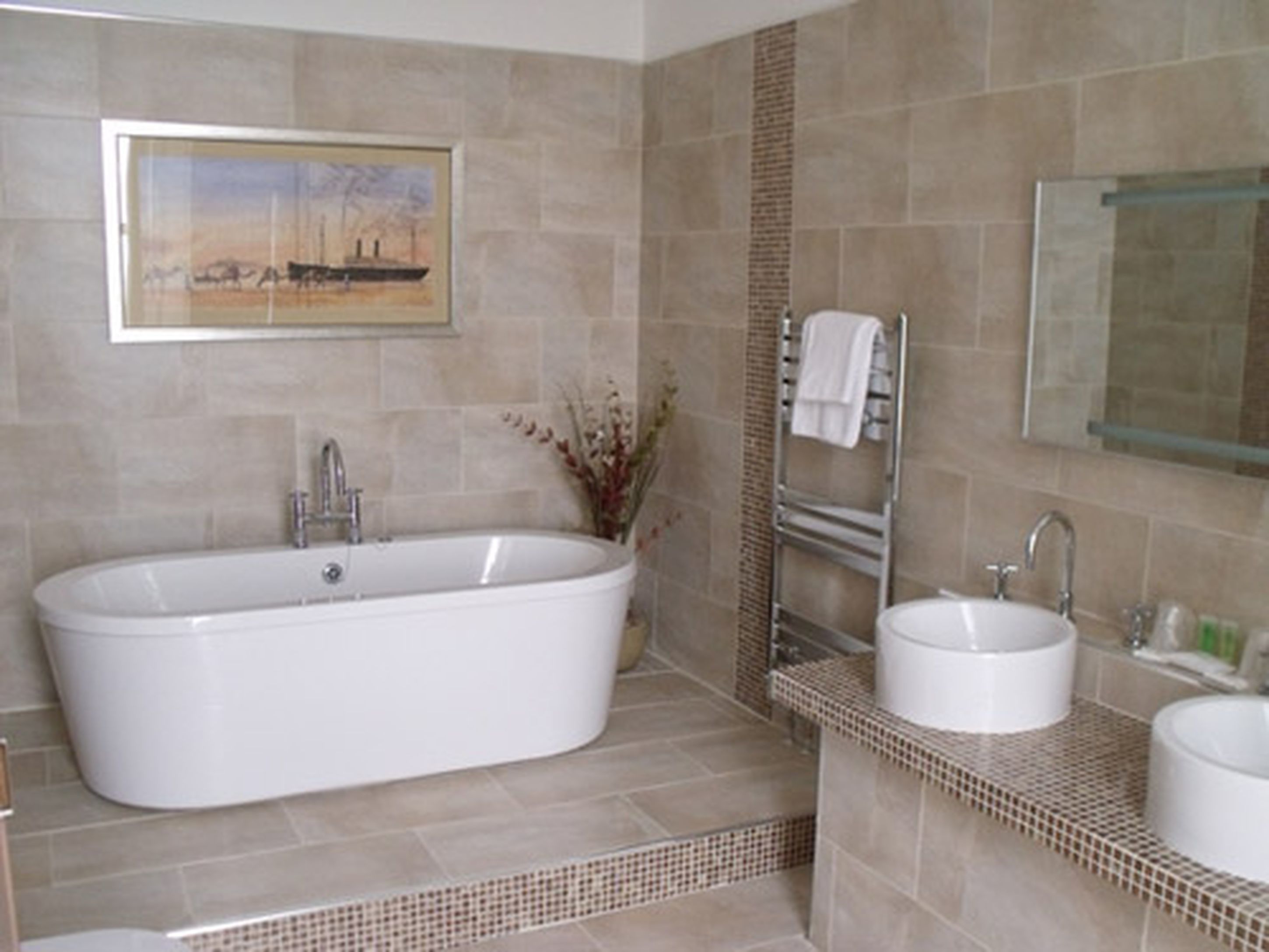 Un baño moderno con una bañera independiente, un lavabo y un espejo.