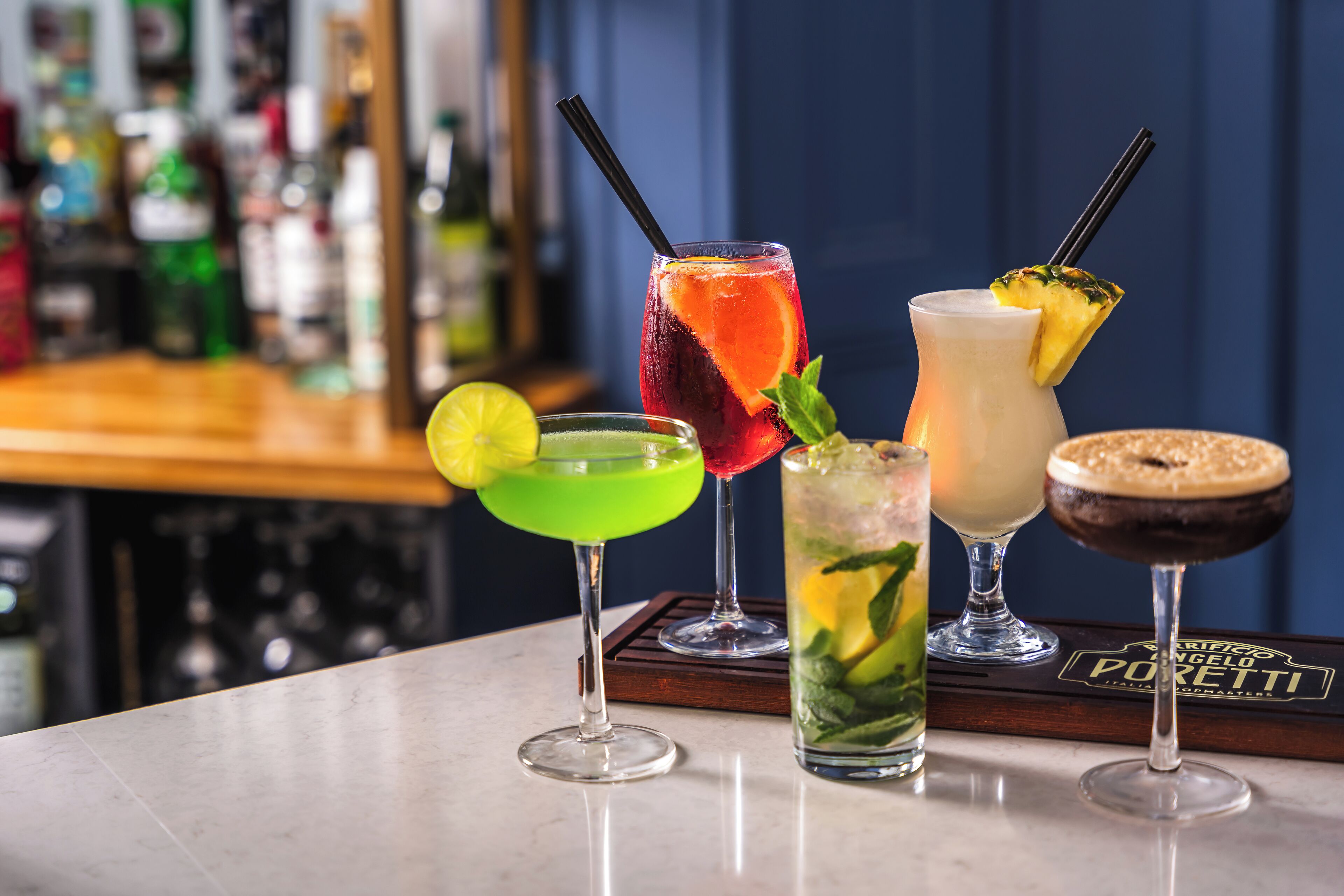 A bar with various cocktails on a tray.