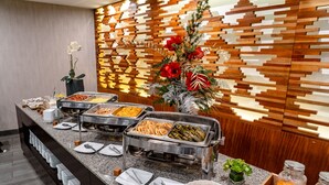 Una mesa de buffet con diversas opciones de comida y un centro decorativo.