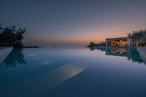 A modern building with a pool, surrounded by trees, during twilight. - Ilyessa Cottages (Zakynthos)
