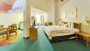 A bedroom with a large bed, a wooden desk, a chair, and a small table. - Capital O Amerihost Inn and Suites Mexico Hwy 54 MO (Mexico)