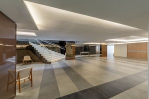 Step into a welcoming space with a central staircase, seating area, and functional storage.
