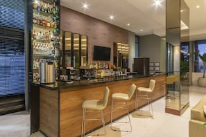 Enjoy a drink at the bar, where a large TV and mirror create a welcoming atmosphere.