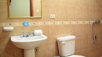 A bathroom with a sink, toilet, and shower.