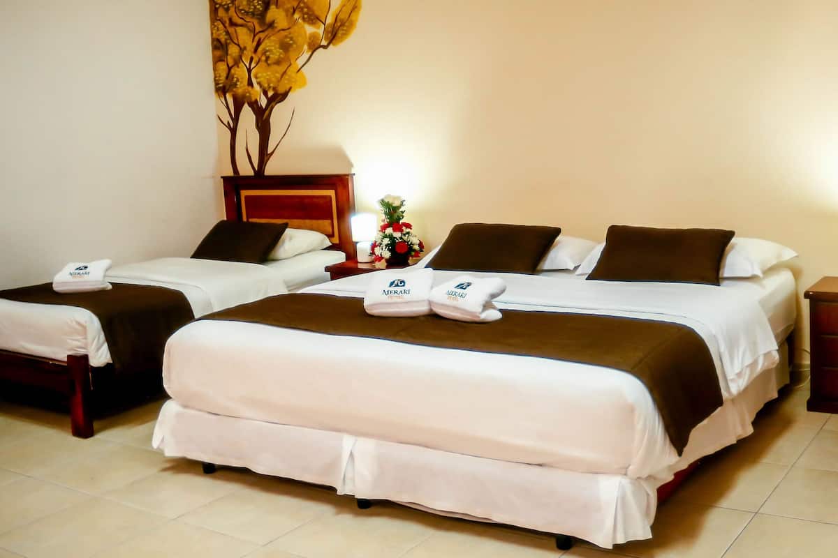 A hotel room with two beds, a nightstand with a lamp, a wooden cabinet, and a wall decoration.