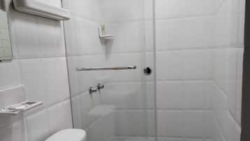 Un vestuario pequeño y cerrado con puerta de vidrio, un inodoro y un lavabo.