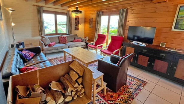 A cozy living room with a sofa, chairs, a coffee table, a TV, and a fireplace. - Chalet in Hampteau with Valley Views (Hampteau)