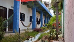 A courtyard with a hammock, potted plants, and a pathway. - Casa Torices Real 12  (Cartagena)