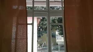 Une fenêtre avec un cadre blanc et des rideaux orange.
