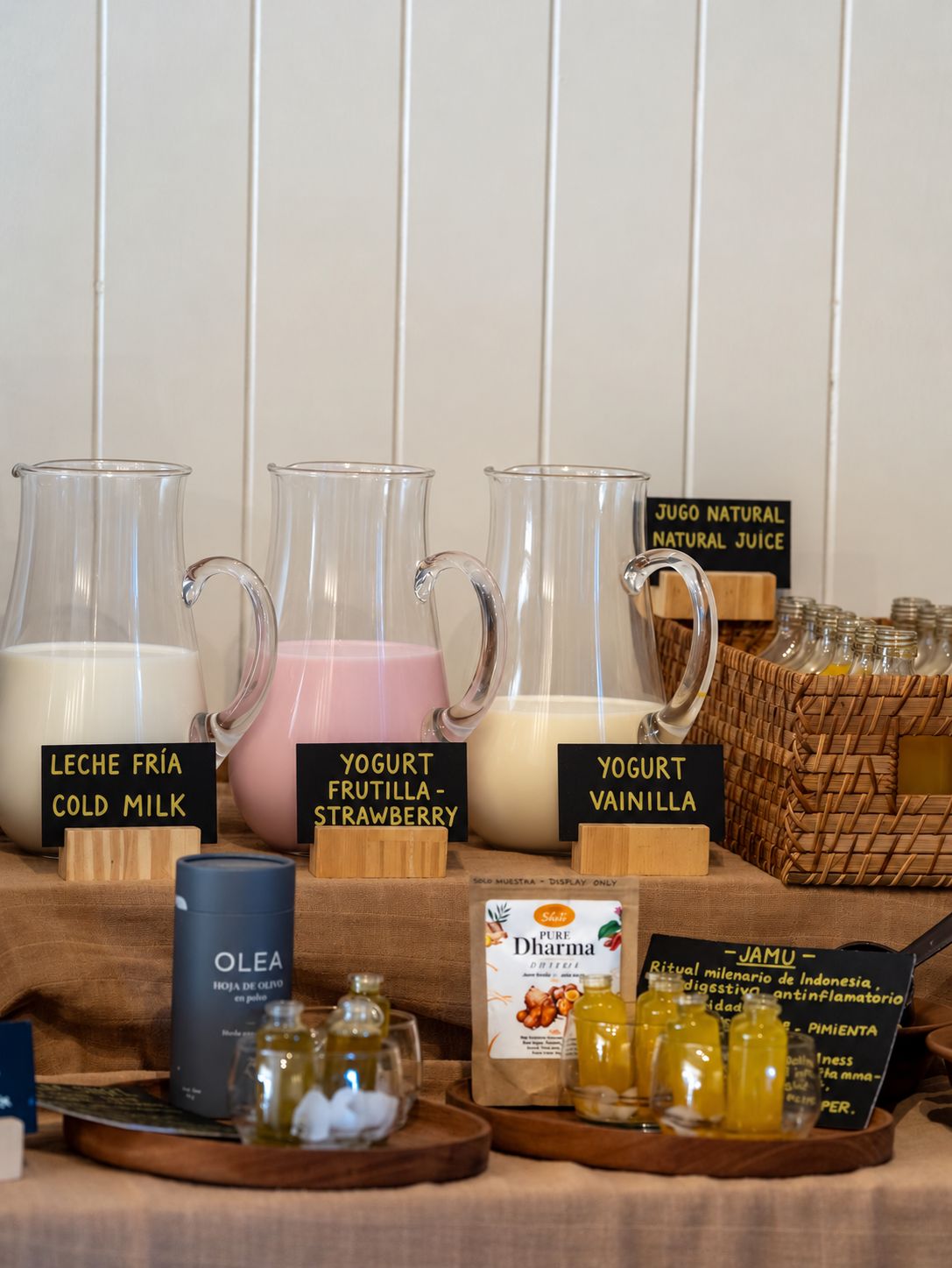 Se exhiben bebidas como leche fría, yogur de fresa y yogur de vainilla, junto con un tarro de aceite y un frasco de mermelada.