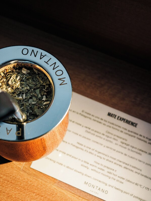 A wooden ashtray with ashes and a cigarette butt, a menu, and a wooden table.