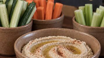 A table with hummus and various vegetables.