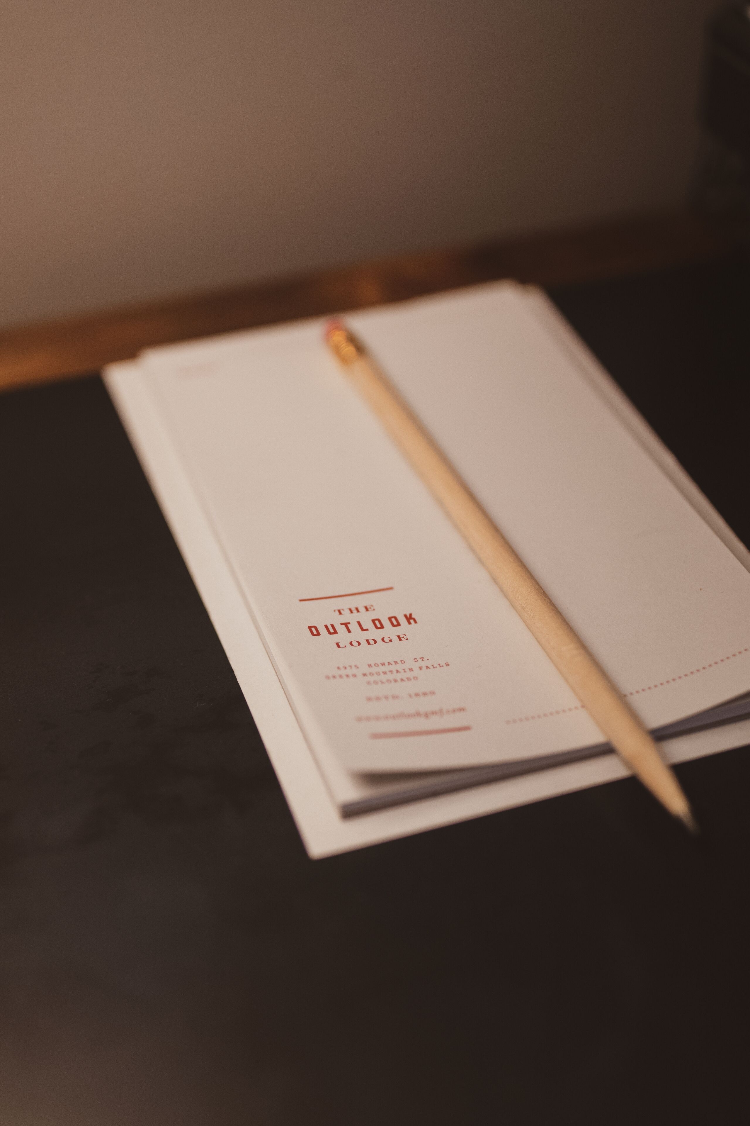 Un livre ouvert intitulé « The Outlook Lodge », avec un marque-page en bois.