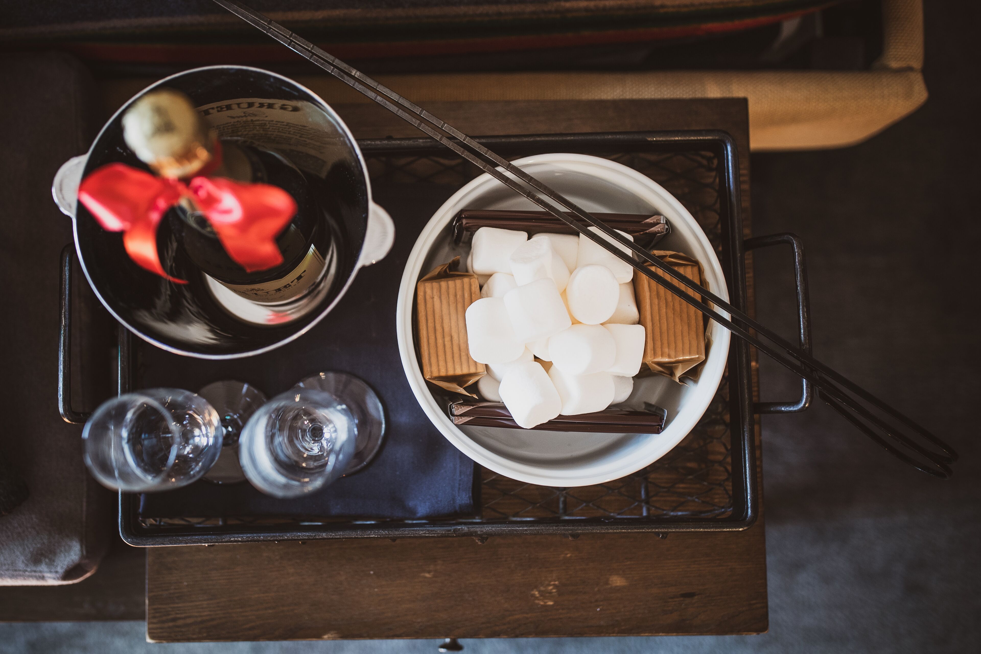 A tray with a bowl of white items, possibly food, and a bottle with a red label.