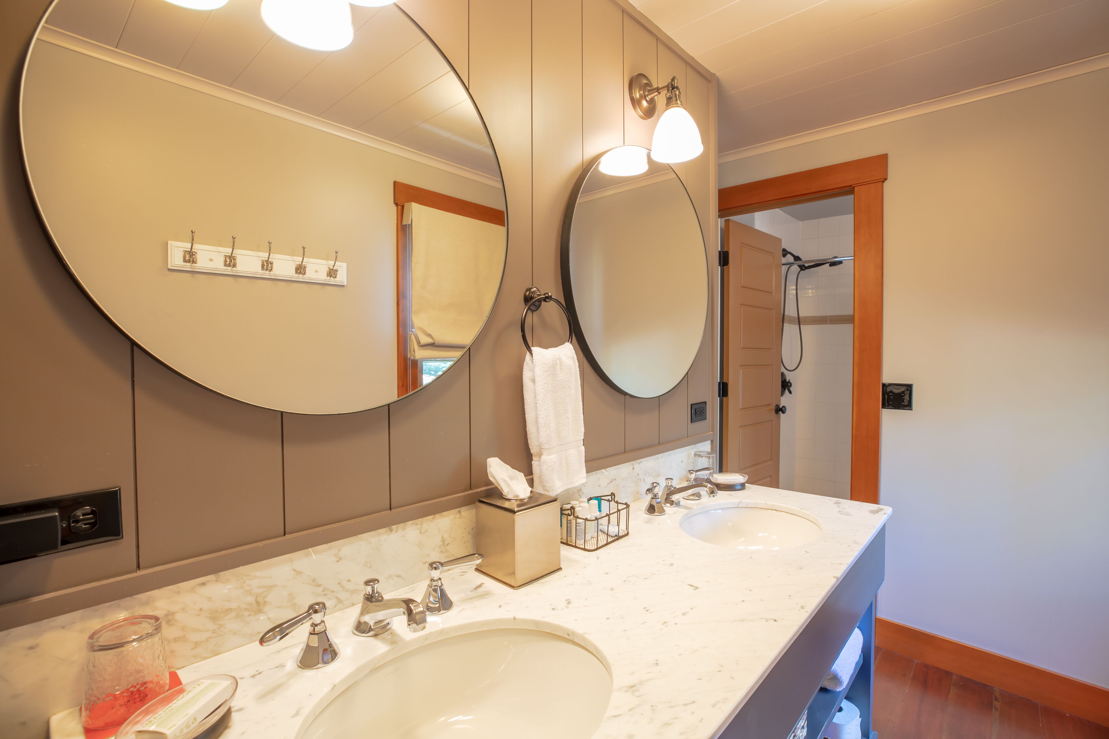 Un bagno con due lavandini, uno specchio grande e una zona doccia.