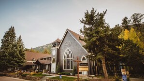 A church with a steeple, a signboard, and a parking sign. - Little Beaver Inn (Green Mountain Falls)