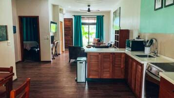 A compact kitchen with wooden cabinets, a sink, and a dining area with a table and chairs.