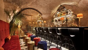A bar area with a checkered floor, red velvet seating, and a variety of stools. - Villa Brown Jerusalem (Jerusalem)