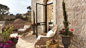 A balcony with wicker chairs, a potted plant, and a fruit basket. - Villa Brown Jerusalem (Jerusalem)