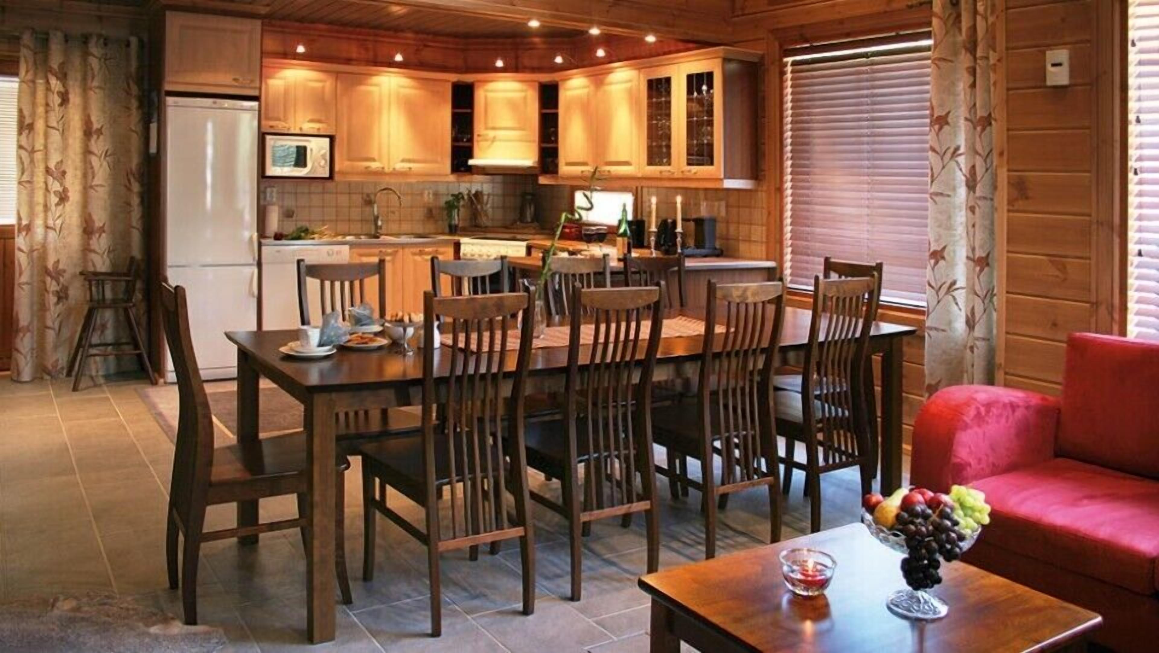 Una cucina accogliente con mobili in legno, un tavolo da pranzo con sedie e un divano rosso.