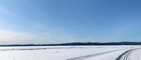 Uma estrada coberta de neve com marcas de pneus.