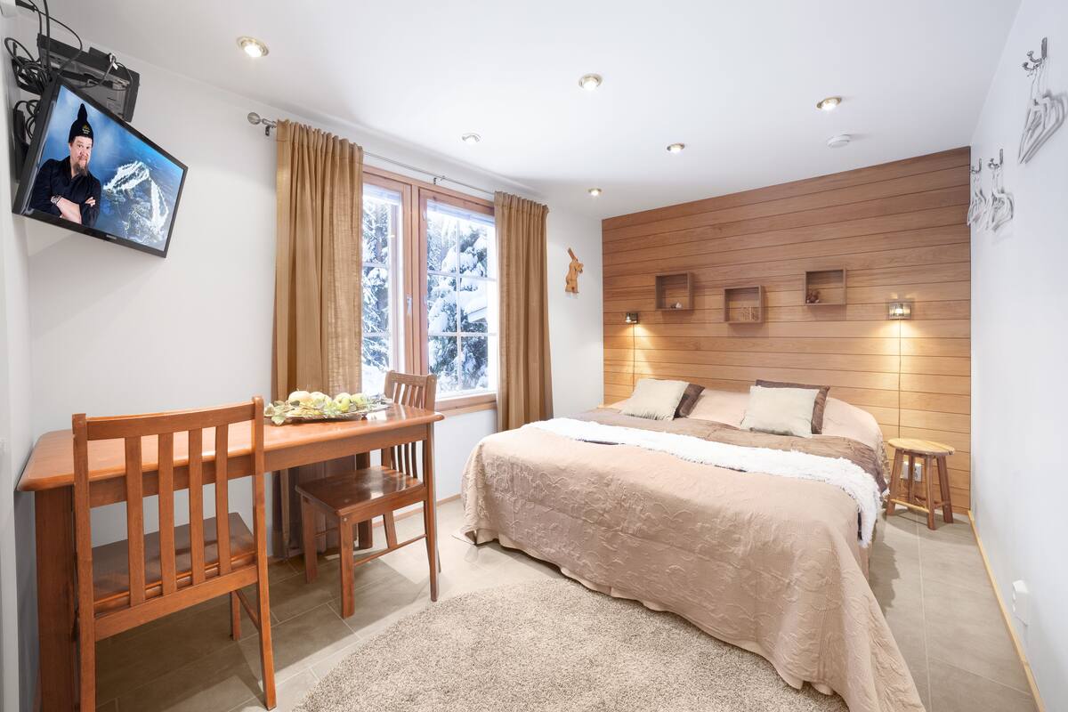 Un dormitorio con cama, escritorio y televisor.