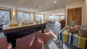 A spacious room with a pool table, dining area, and large windows offering natural light. - Terama Ski Lodge (Mount Buller)