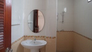 A bathroom with a white sink, a mirror, and a shower. - Sweet Home Chiang Khan (Chiang Khan)
