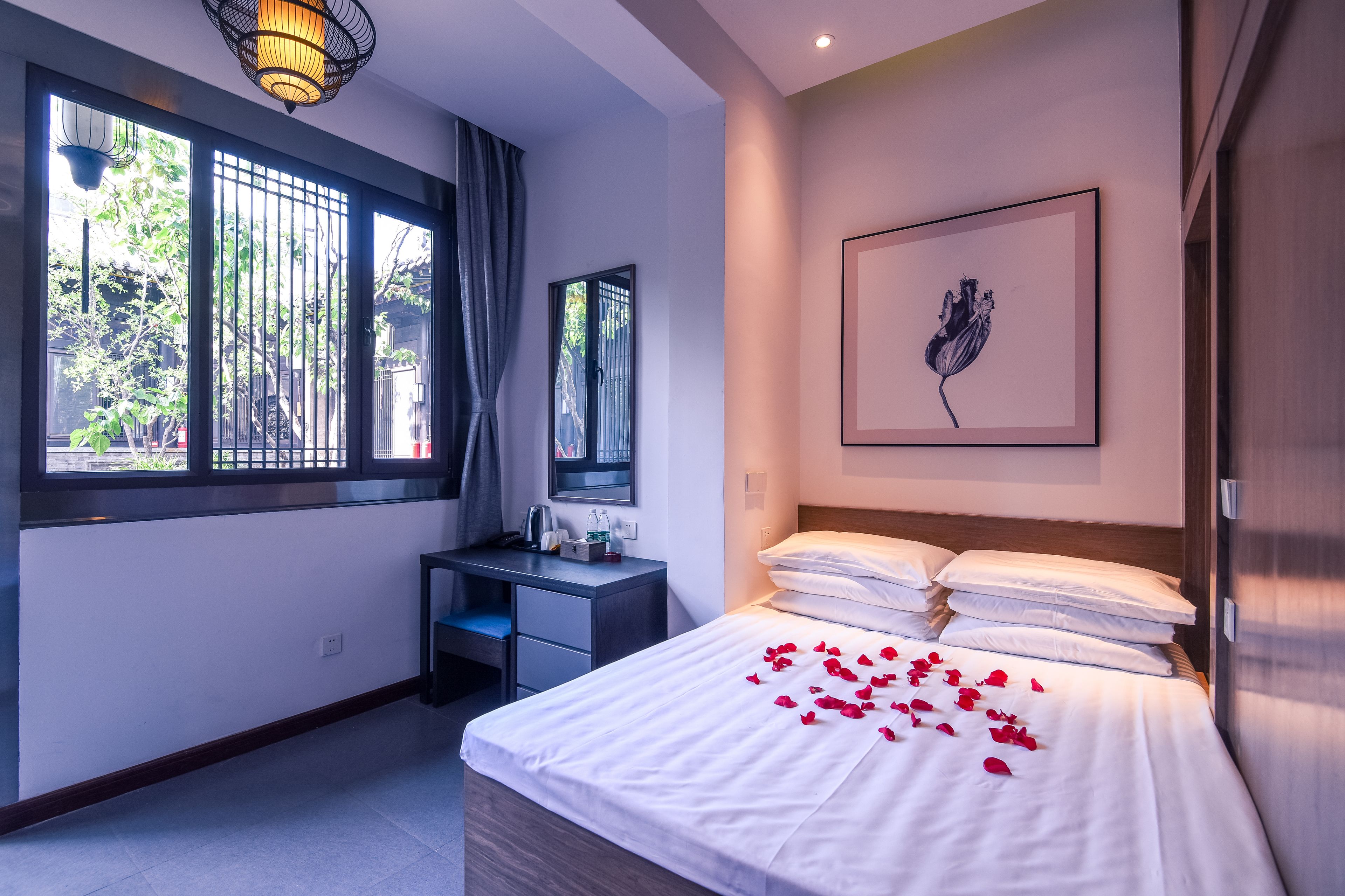 Habitación de hotel con cama, escritorio y ventana con cortinas.