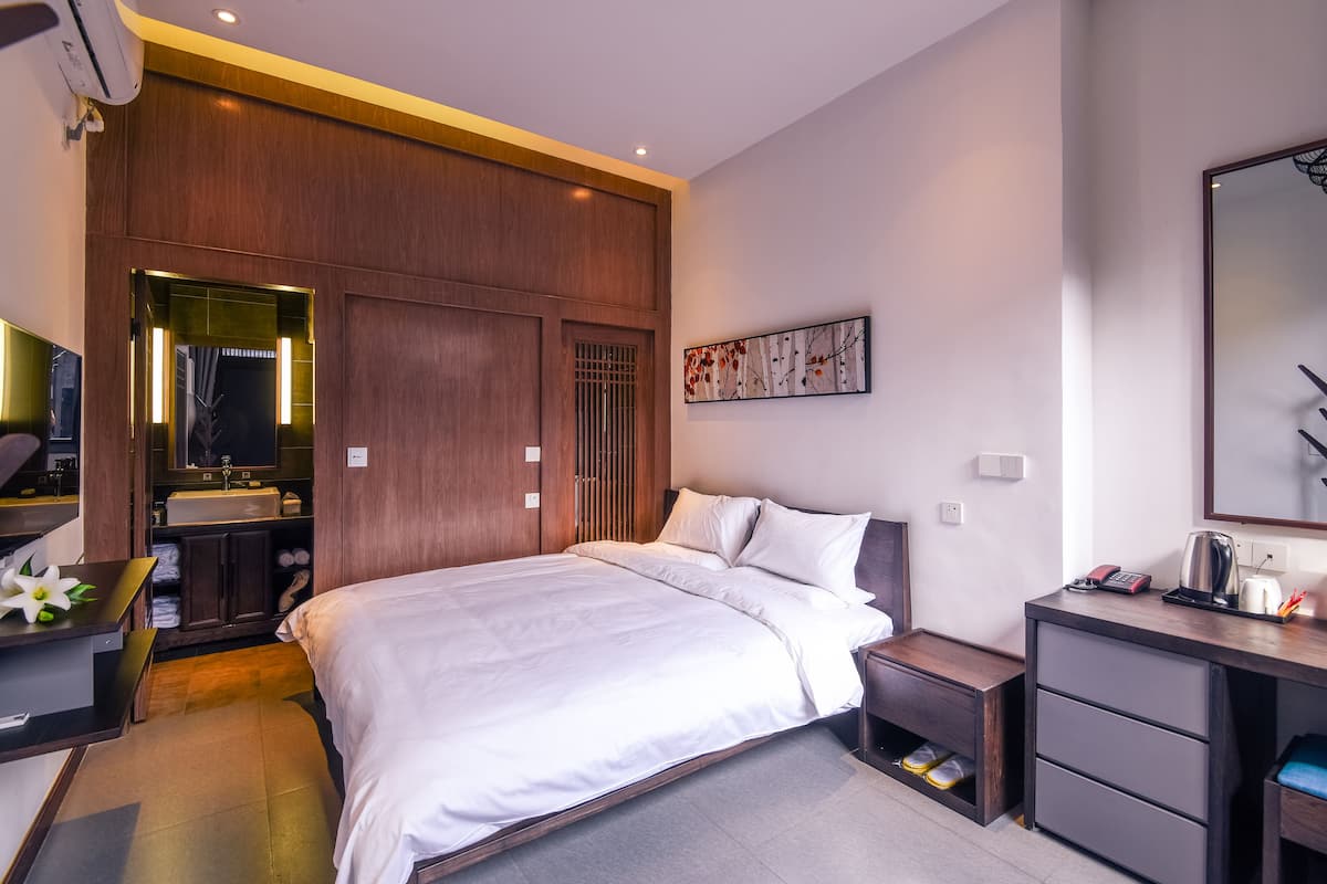 Une chambre à coucher moderne avec un grand lit, un bureau et une armoire.
