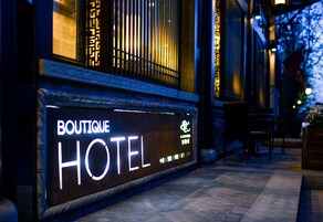 Señal de un hotel boutique con diseño moderno e iluminación de letras.