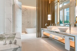 Une salle de bain moderne avec une grande baignoire, un meuble-lavabo à deux vasques et un grand miroir.
