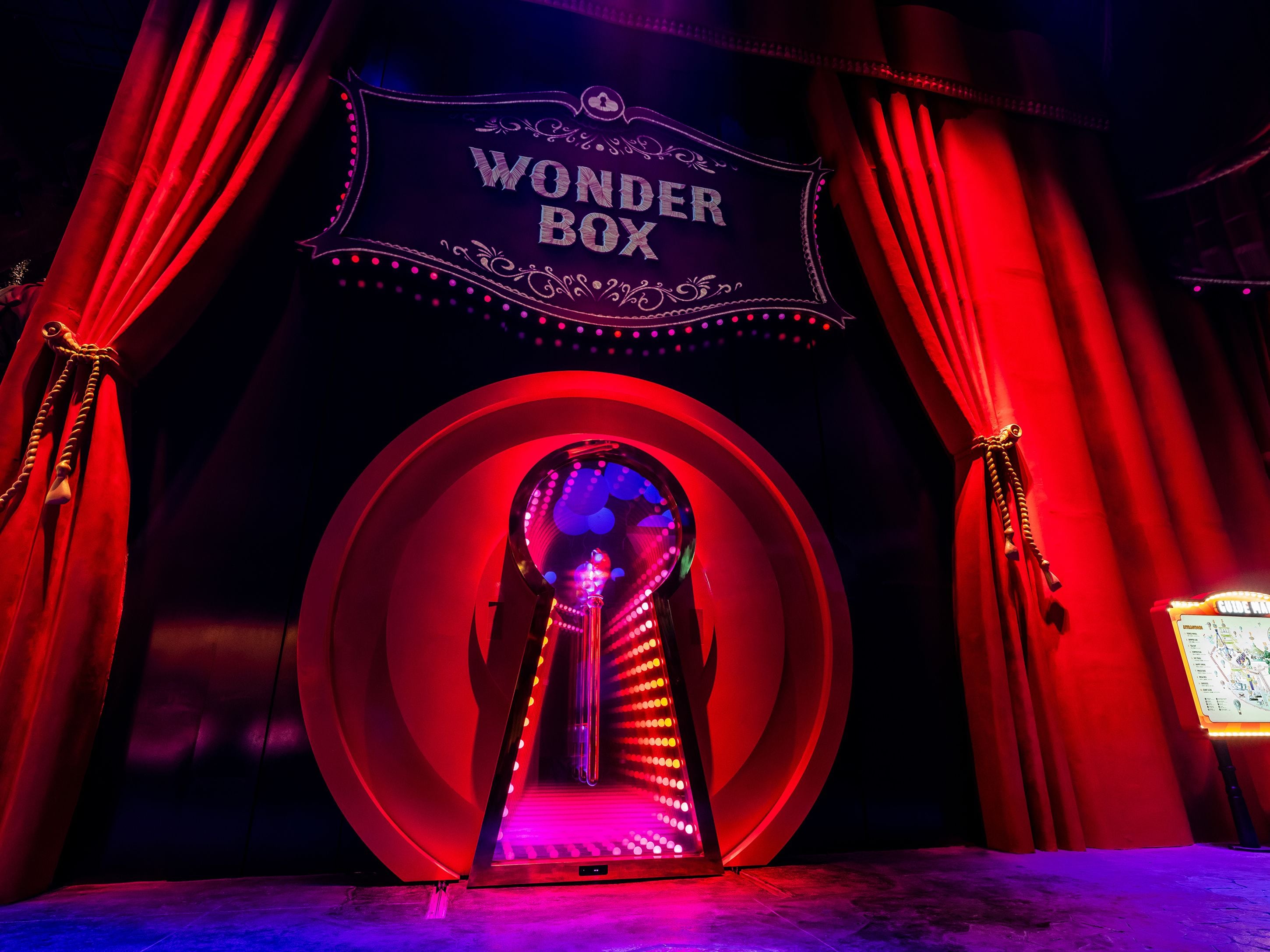 A theater entrance with a sign reading "WONDER BOX" and red curtains.