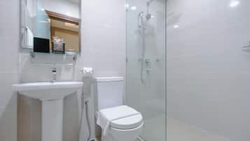 A modern bathroom with a glass-enclosed shower, a white sink, and a toilet.