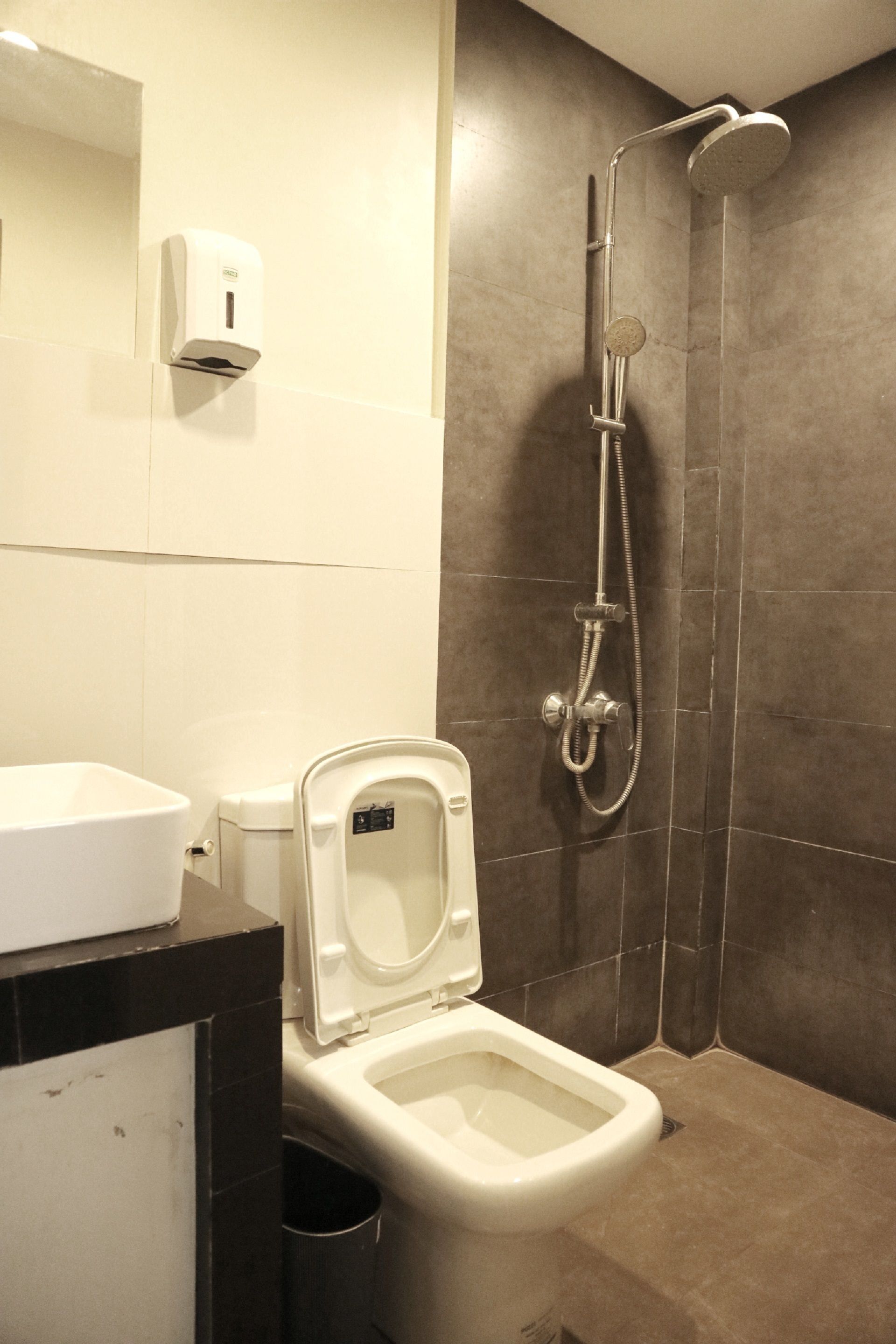 A modern bathroom with a toilet, bidet, and shower.