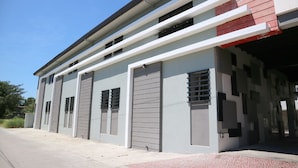 A modern building with multiple garage doors, a flat roof, and a clean, minimalist design.