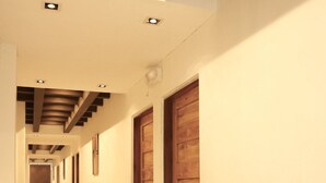 A long, narrow hallway with wooden doors and recessed lighting.