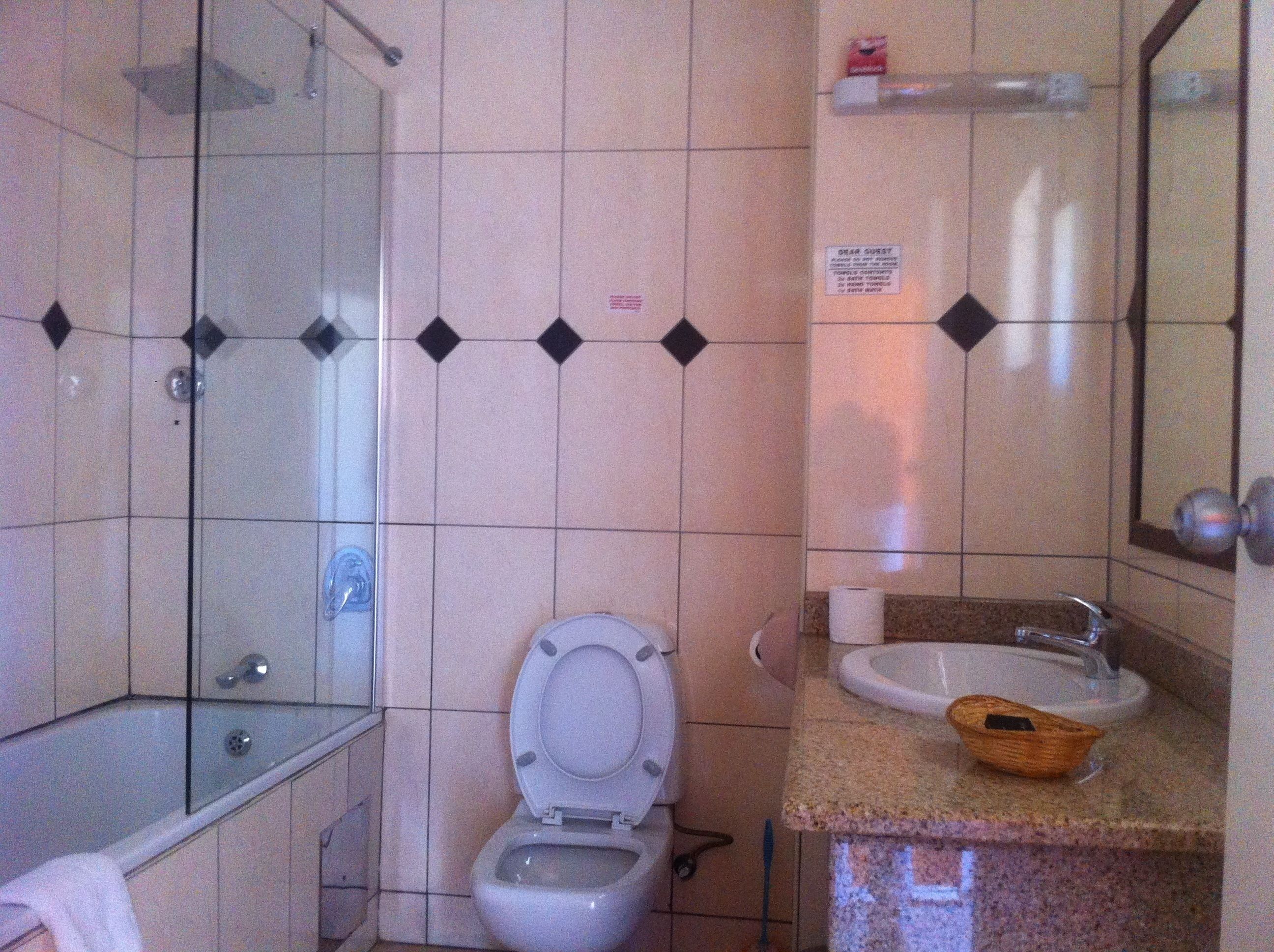 Un baño con inodoro, lavabo y ducha.