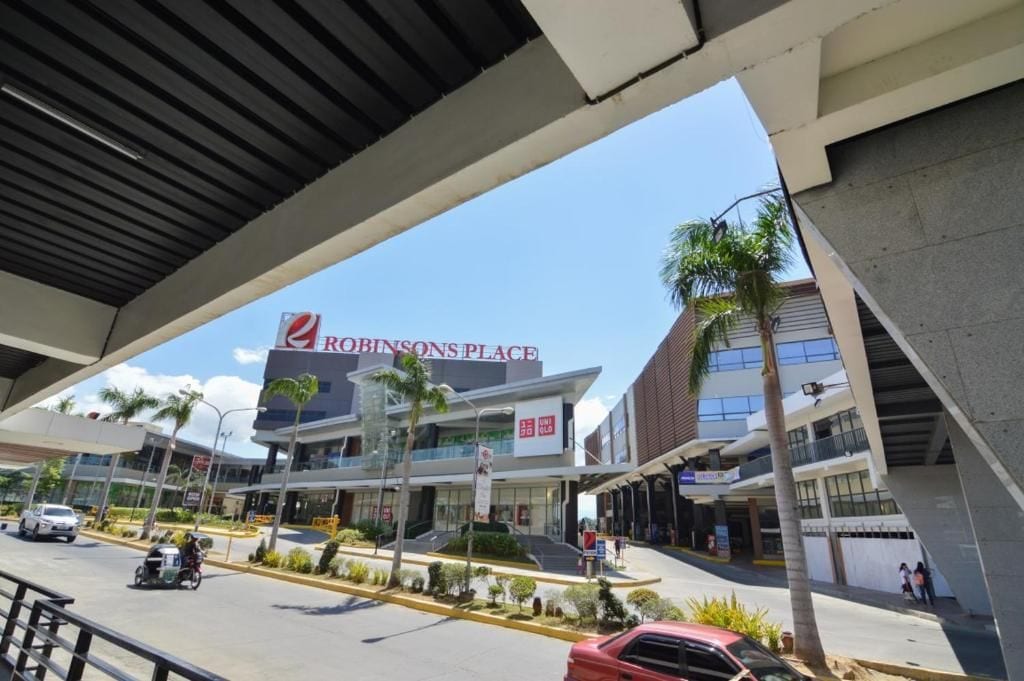 A modern shopping center with a prominent Robinsons Place sign.