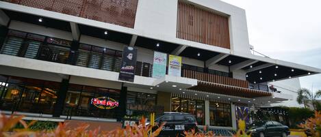 Un edificio moderno de varios pisos, con un restaurante llamado 'Shaleys' en la planta baja.
