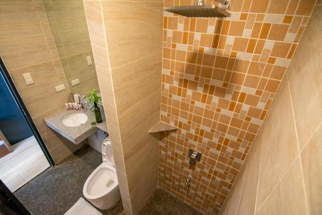 A bathroom with a toilet, sink, and shower area.