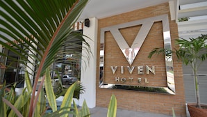A hotel sign with the name "VIVEN HOTEL" and a large V-shaped mirror design. - Viven Hotel (San Nicolas)