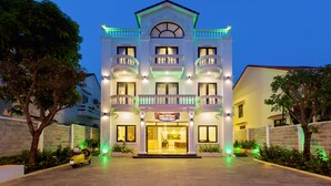 A multi-story hotel with a grand entrance, balconies, and a well-lit facade. - Terrace Villa Hoi An (Da Nang)